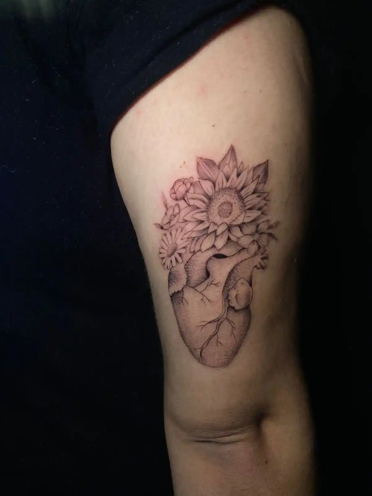 Tatuaje de corazón humano con flores.